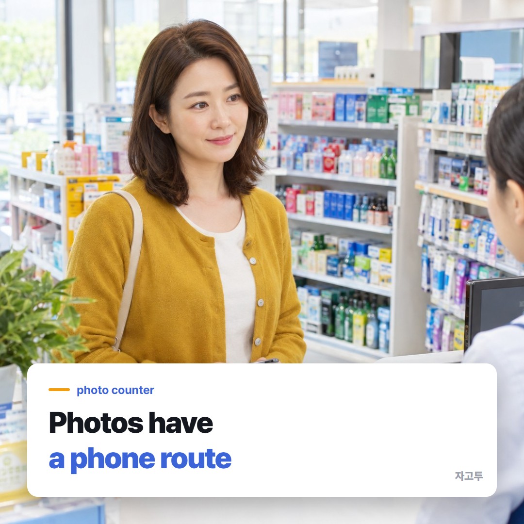 A woman at a pharmacy photo counter holding her phone